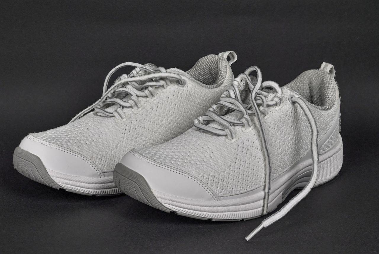 Stylish white sneakers with detailed lace ties and modern design.